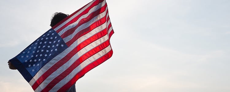 Joven alzando la bandera de Estados Unidos después de leer las frases legendarias en inglés
